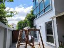 Modern two-story house exterior with spacious patio and swing