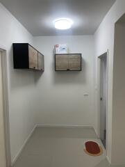 Compact hallway with mounted storage cabinets and white tiled flooring