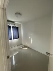 Empty room with glossy white tiled floor and a window with dark curtains