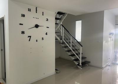 Modern interior of a building with large decorative wall clock and staircase