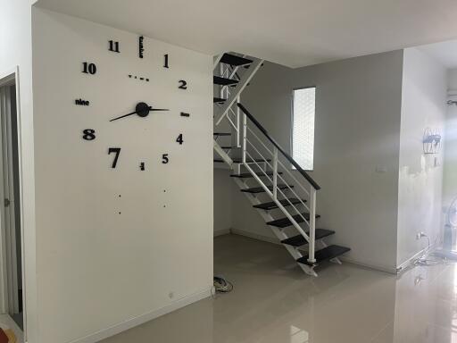 Modern interior of a building with large decorative wall clock and staircase