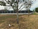 Spacious outdoor area with greenery and fencing