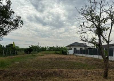 Suburban home exterior with open land under a cloudy sky