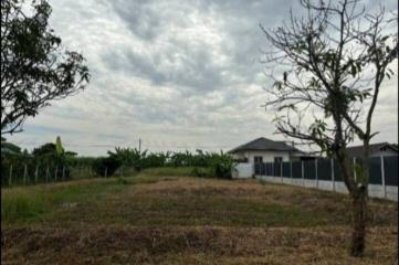 Suburban home exterior with open land under a cloudy sky