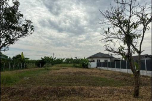 Suburban home exterior with open land under a cloudy sky