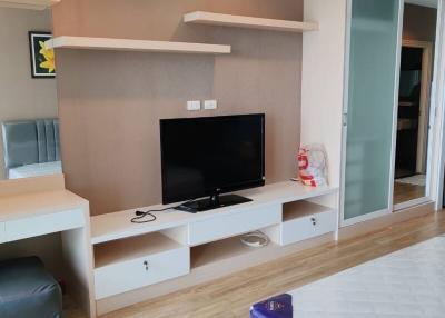 Modern bedroom with entertainment wall unit and wooden flooring