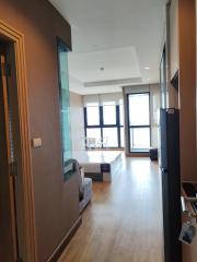 Modern apartment interior view showcasing the entrance leading to a living area with expansive windows and abundant natural light