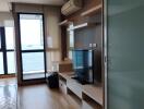 Modern living room with a view of the sea, featuring wooden flooring and a wall-mounted TV setup