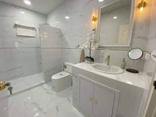 Modern white tiled bathroom with gold fixtures