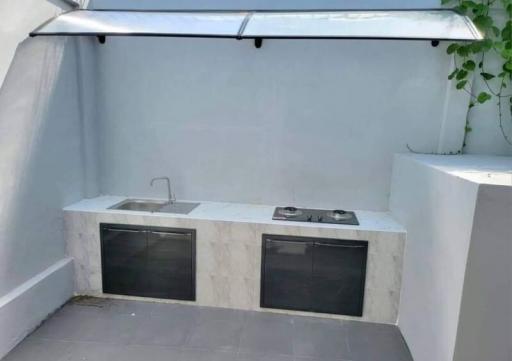 Outdoor kitchen area with sink and grill