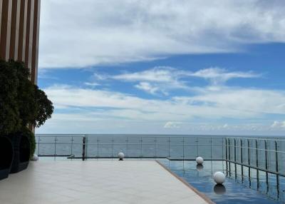 Infinity pool with a sea view beside a modern building