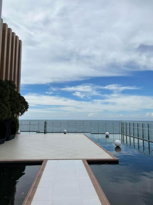 Infinity pool with a sea view beside a modern building