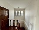 Bright hallway with wooden flooring and staircase