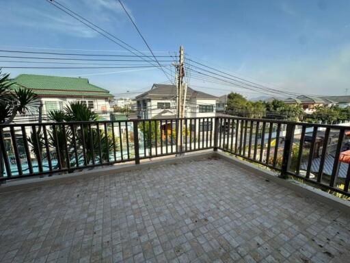 Spacious balcony with tile flooring overlooking neighboring houses