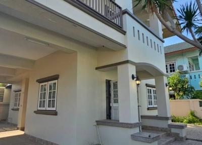 Modern two-story house with balcony and paved driveway