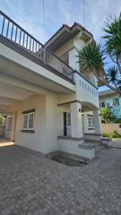 Modern two-story house with balcony and paved driveway