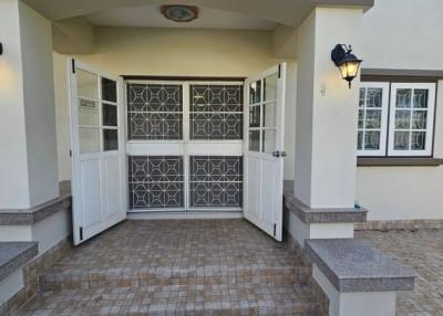 Front entrance of a residential building with decorative door and brick pavement
