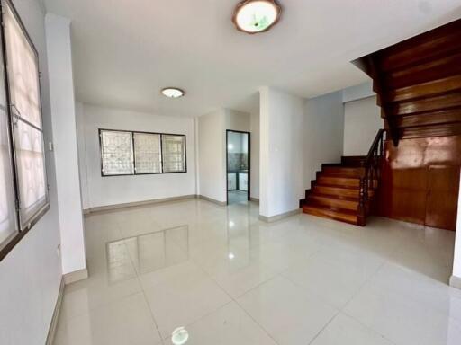 Spacious living area with staircase and natural lighting