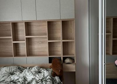 Cozy bedroom interior with built-in wardrobe and shelving units
