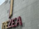 Exterior view of 'THE ZEA' building with large signage