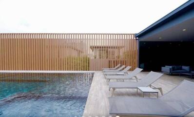 Modern home outdoor area with swimming pool and loungers