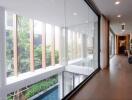 Modern hallway with floor-to-ceiling windows and hardwood floors