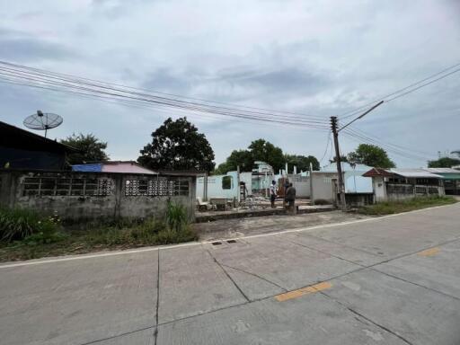 Empty residential lot with surrounding neighborhood and overcast sky