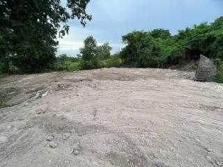 Vacant lot ready for construction with greenery in the background