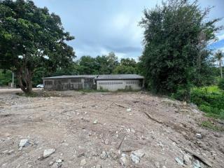 Sparse outdoor area with a storage building and scattered debris