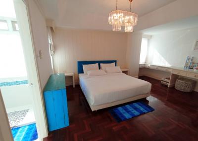 Bright and spacious bedroom with wooden flooring and blue accents