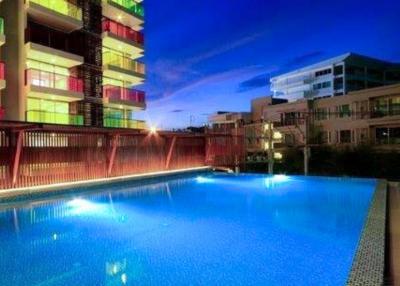 Modern building exterior with illuminated pool during twilight