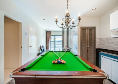 Spacious game room with pool table, modern chandelier, and open layout
