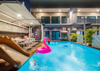 Modern house with pool and outdoor dining area at night