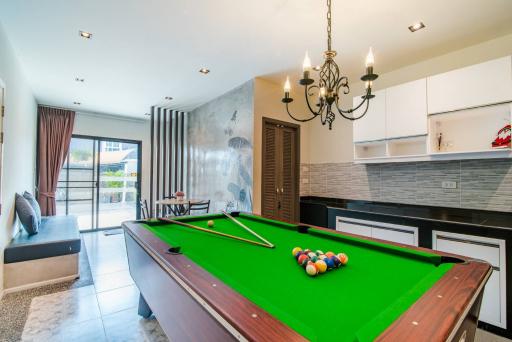 Spacious recreational area with pool table, modern kitchen, and comfortable living space