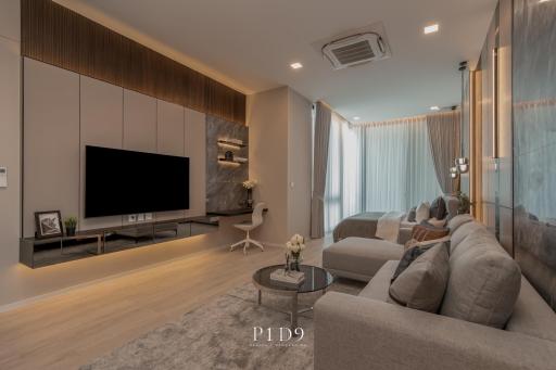 Modern and spacious living room with L-shaped sofa, flat screen TV and wooden accents
