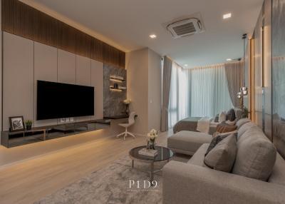 Modern and spacious living room with L-shaped sofa, flat screen TV and wooden accents