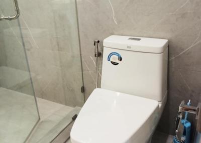 Modern bathroom with a wall-mounted toilet and glass shower door