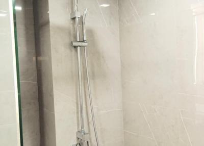 Modern bathroom with wall-mounted shower head and marble tiles