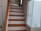 Modern wooden staircase with white walls and large window