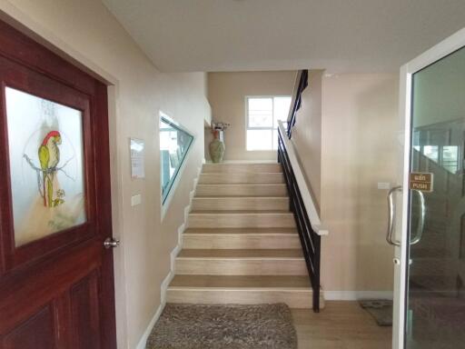 Spacious hallway with wooden stairs and modern wall art