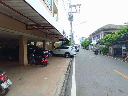 Parking area of a residential building with cars and motorcycles