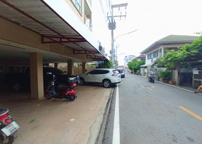 Parking area of a residential building with cars and motorcycles