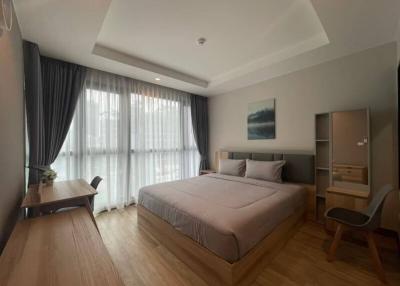 Spacious bedroom with natural lighting and modern furnishings