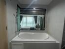 Modern bathroom with bathtub and view to the bedroom through a glass window