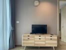 Minimalist living room with television set and wooden cabinet
