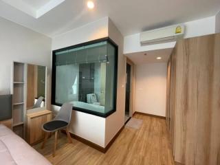 Modern bedroom with large window overlooking the bathroom and wooden wardrobe