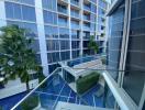 Spacious balcony with a view of the building courtyard and swimming pool