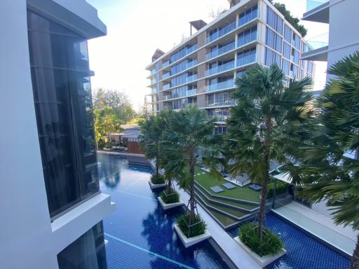 View from balcony showcasing pool and garden area in a modern apartment complex