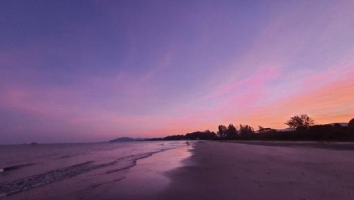 Serene beach sunset with vibrant skies reflecting on wet sand