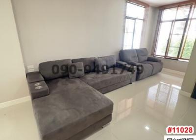 Spacious living room with large grey sectional sofa and bright window